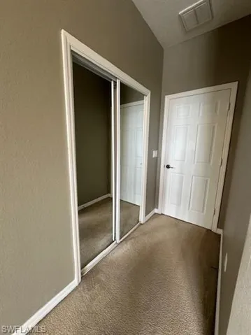 Unfurnished bedroom featuring a closet and carpet floors