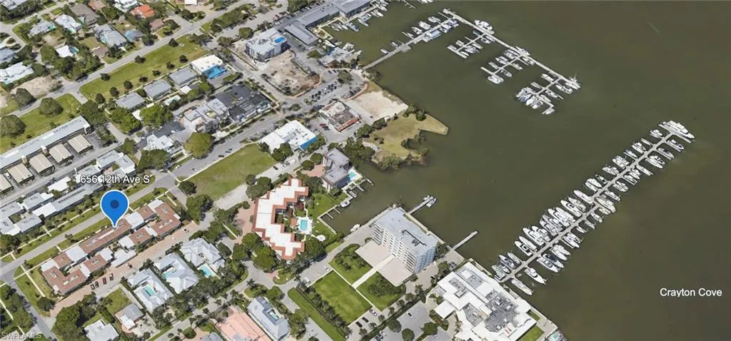 Aerial overview of property's location featuring a marina and a large body of water