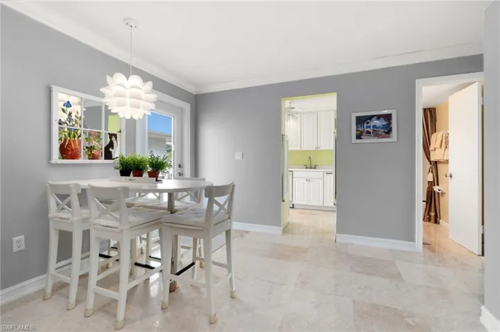 Dining area with ornamental molding and a chandelier