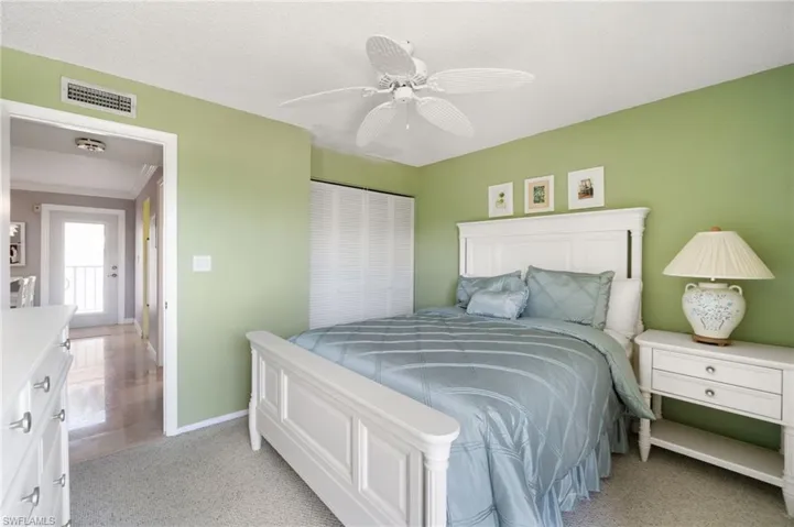 Bedroom featuring a closet, ceiling fan, and light colored carpet