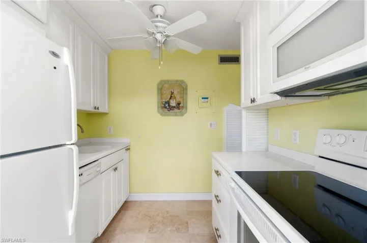 Kitchen featuring white appliances, light countertops, white cabinets, and ceiling fan