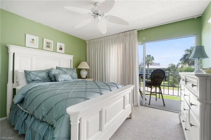 Bedroom featuring light colored carpet, access to outside, a textured ceiling, and a ceiling fan