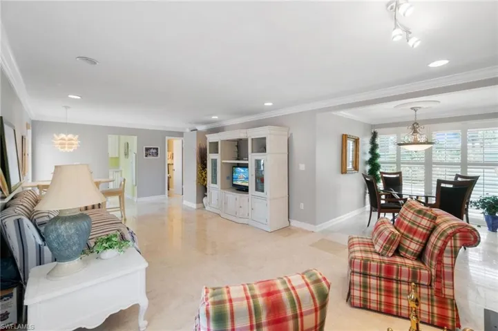 Living area with ornamental molding, recessed lighting, and a chandelier