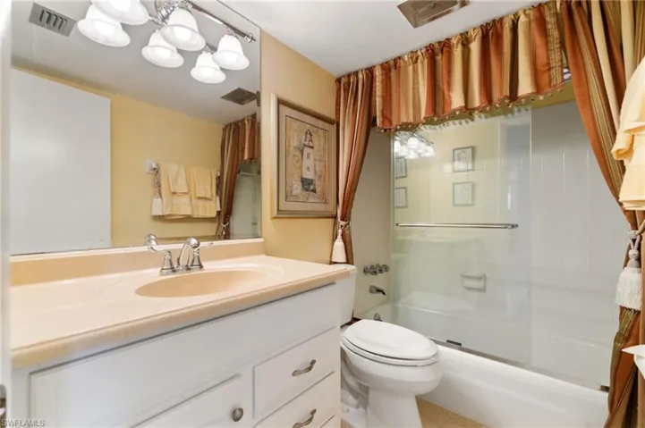 Full bath featuring vanity and enclosed tub / shower combo