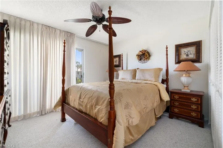 Bedroom with carpet, a textured ceiling, and a ceiling fan