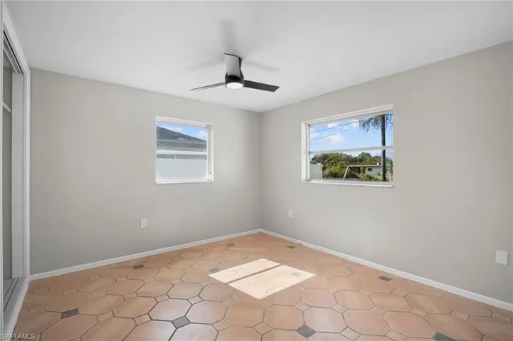 Unfurnished room with baseboards and a ceiling fan