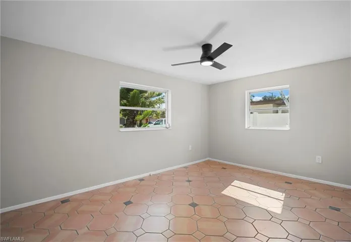Unfurnished room featuring plenty of natural light and a ceiling fan