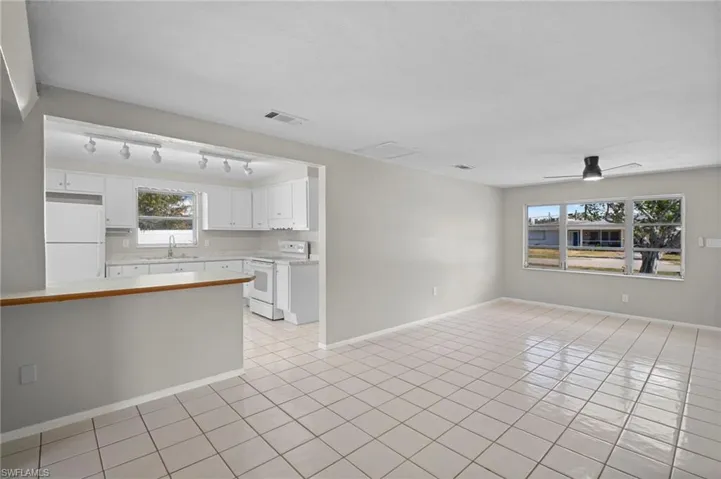 Kitchen with light countertops, white appliances, white cabinetry, ceiling fan, and light tile patterned floors