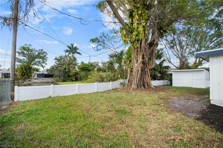 Fenced backyard featuring a storage unit