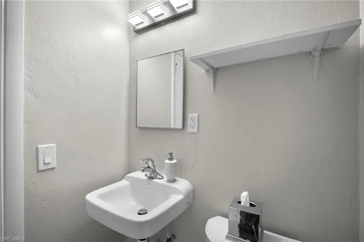 Bathroom featuring a sink and a textured wall