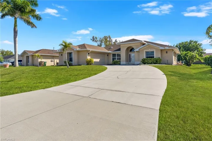 Ranch-style house with a front lawn, stucco siding, an attached garage, and driveway