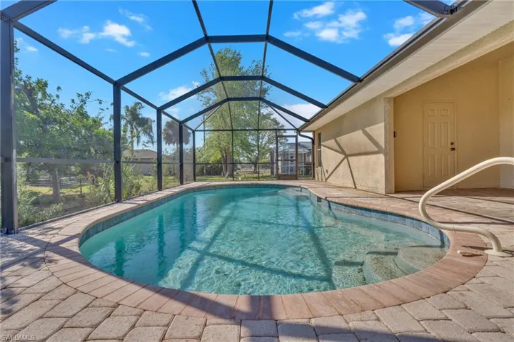 Swimming pool with a sunroom, glass enclosure, and a patio