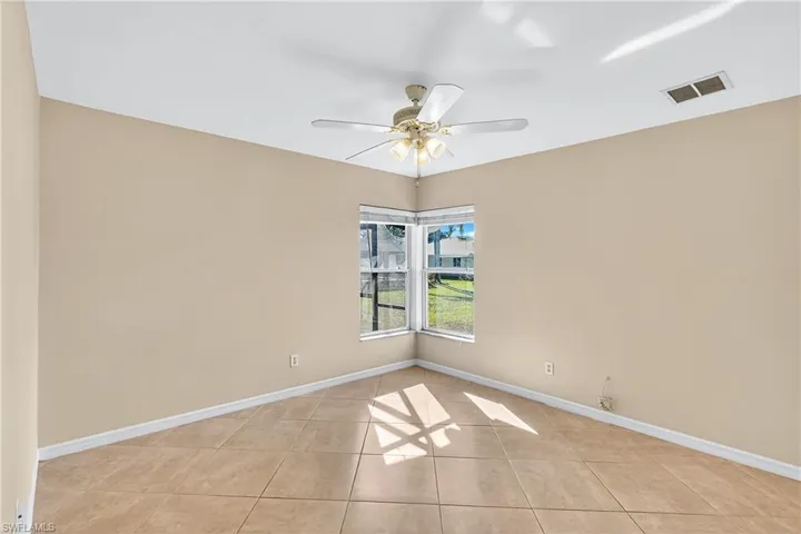 Spare room featuring a ceiling fan and light tile patterned floors