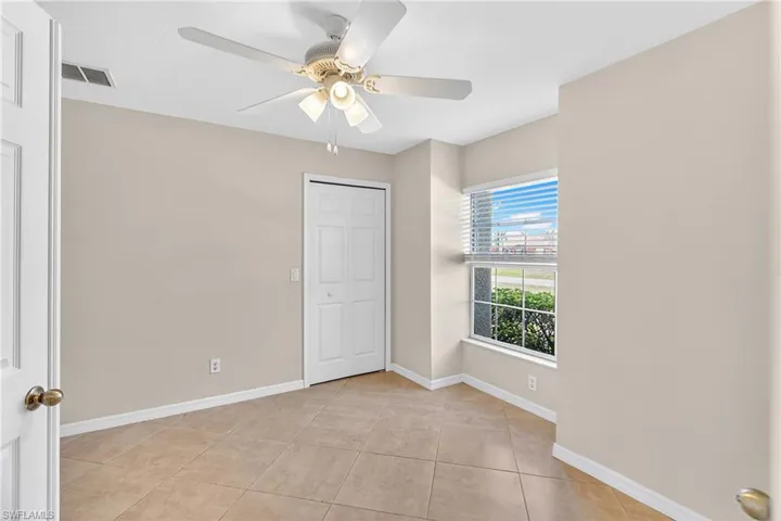 Unfurnished bedroom featuring ceiling fan, a closet, and light tile patterned floors