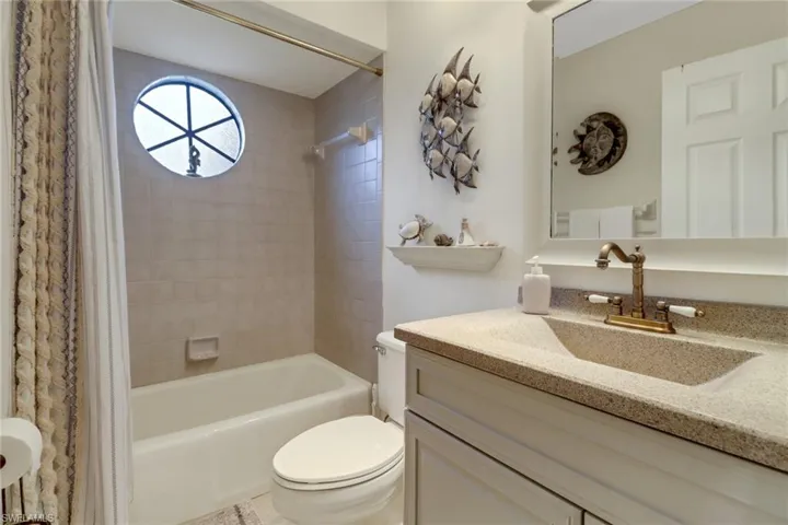 Full bathroom featuring vanity, toilet, and shower / bathtub combination with curtain
