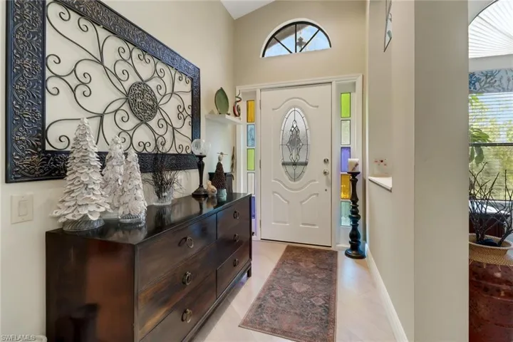 Entrance foyer featuring a healthy amount of sunlight, light tile patterned floors, and a high ceiling