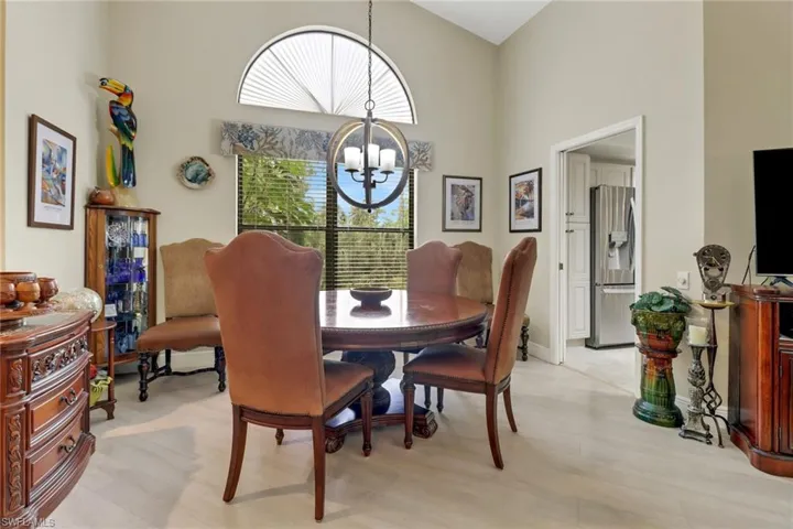 Dining space featuring light hardwood / wood-style floors, a high ceiling, and an inviting chandelier