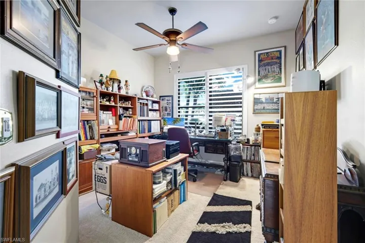 Home office featuring ceiling fan and light carpet