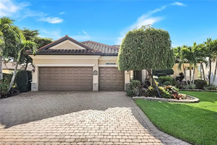 View of front facade with stone siding, an attached garage, decorative driveway, and stucco siding