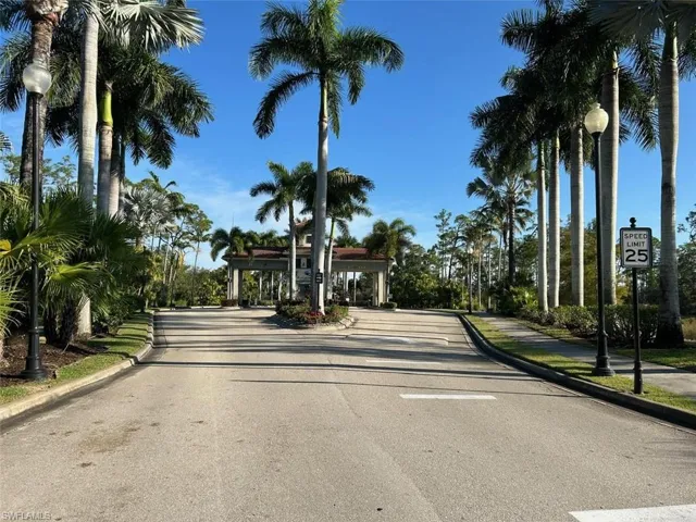 View of asphalt road with curbs, street lighting, traffic signs, and sidewalks
