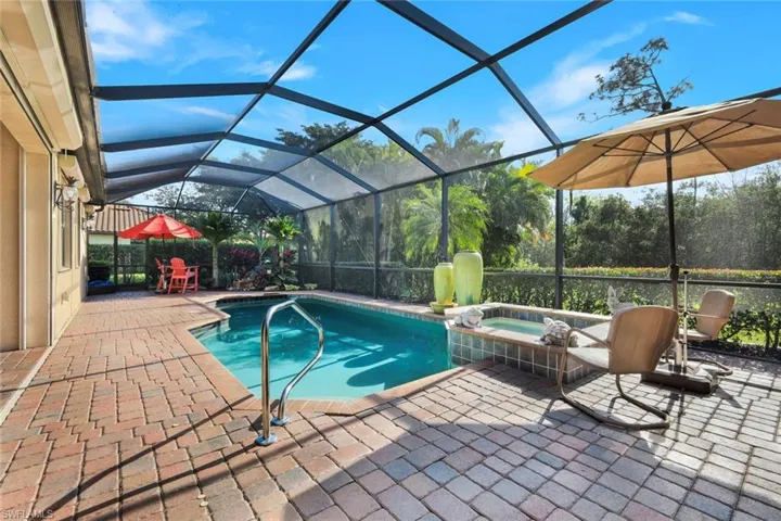 View of swimming pool featuring a sunroom, a patio area, a lanai, and a pool with connected hot tub