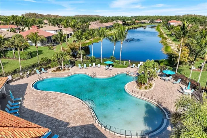 Community pool featuring a water view, a patio, and a residential view