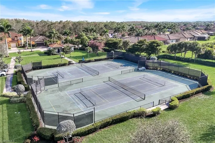 View of tennis court with a residential view