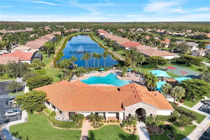 Aerial view of residential area featuring a nearby body of water and a pool