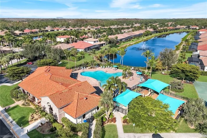 Aerial view of residential area featuring a large body of water and a pool