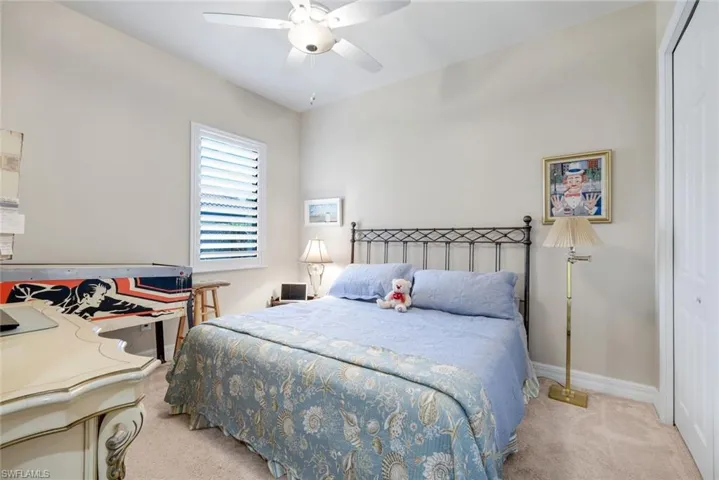 Carpeted bedroom with a closet and ceiling fan