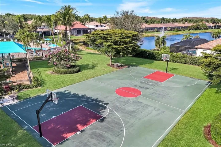 View of basketball court featuring a lawn, community basketball court, and a water view
