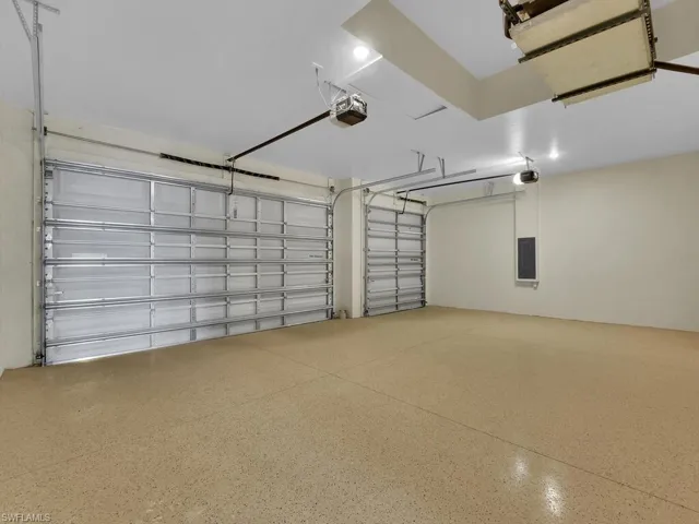 Garage featuring electric panel and a garage door opener