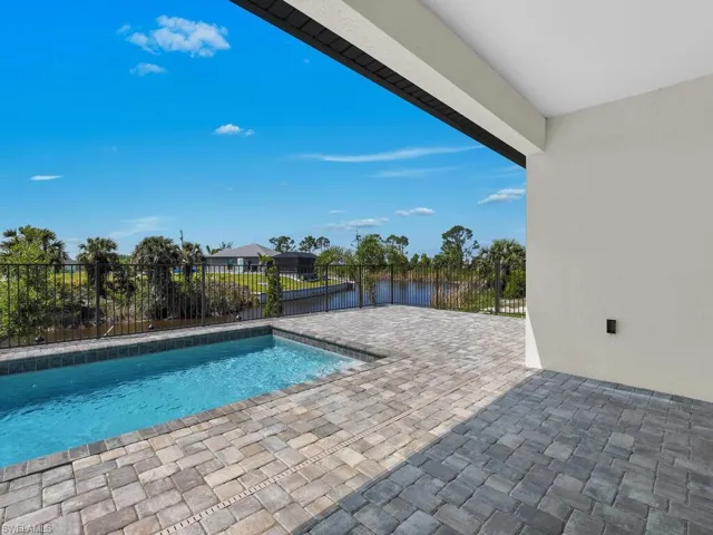 View of swimming pool featuring a patio area, a fenced in pool, a fenced backyard, and a water view