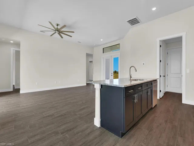 Kitchen featuring visible vents, a ceiling fan, dark wood-style floors, and a sink