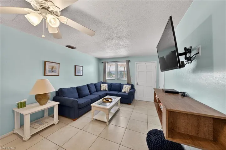 Living space featuring light blue walls and neutral-toned tile flooring