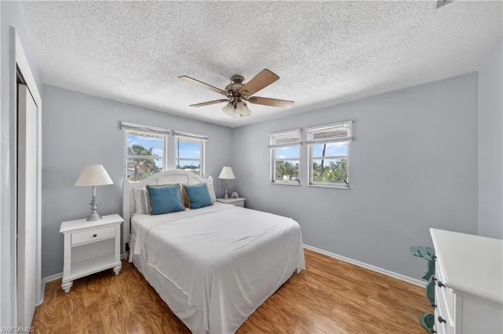 Room featuring wood-finish flooring, light blue walls, and a textured ceiling