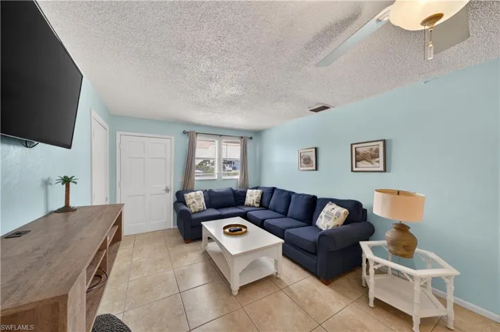 Living area featuring light blue walls and beige tile flooring