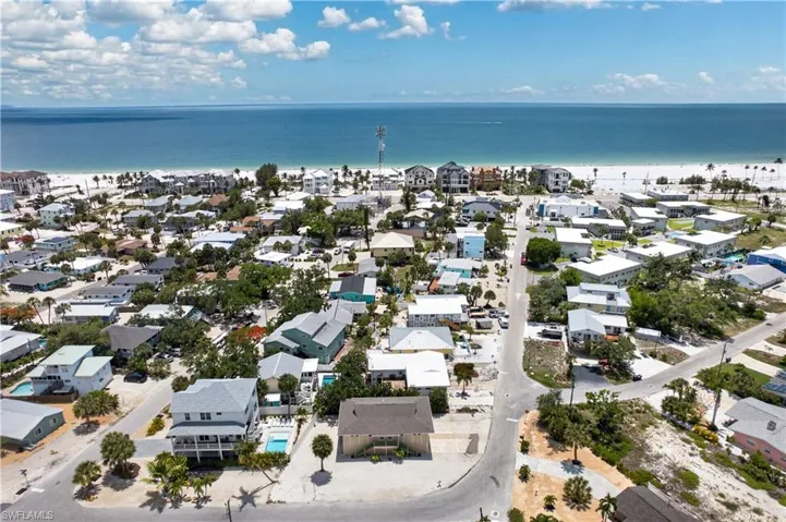 Coastal neighborhood featuring numerous homes, established trees, and white sand beaches