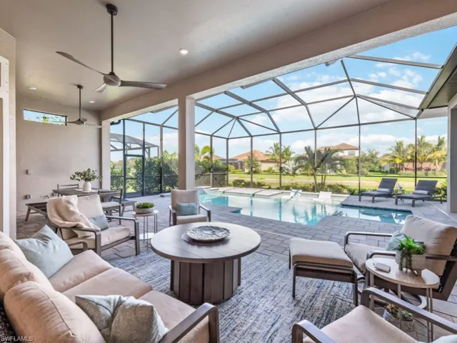 View of patio with a sunroom, a ceiling fan, a lanai, and an outdoor living space with a fire pit