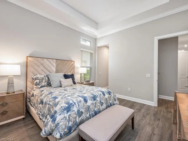 Bedroom featuring dark wood-style flooring and a raised ceiling