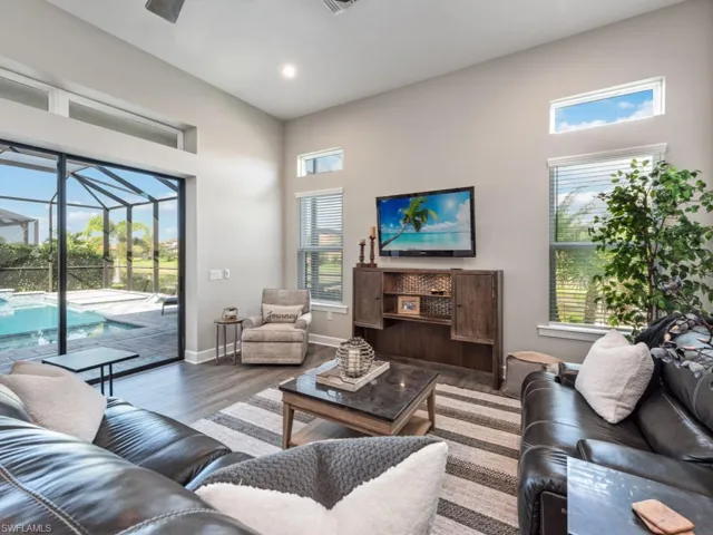 Living area with a sunroom, wood finished floors, a ceiling fan, and recessed lighting