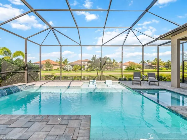 View of pool with a sunroom, glass enclosure, a pool with connected hot tub, and a patio area