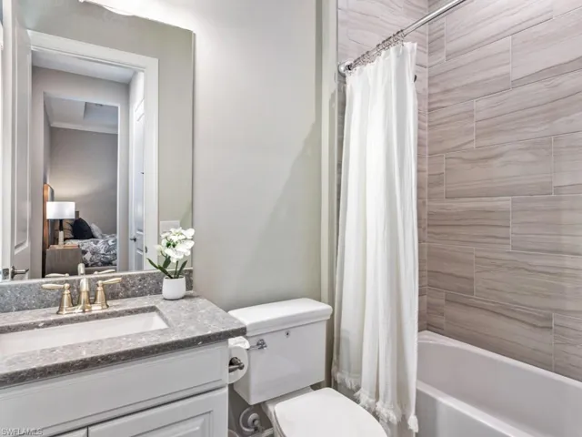 Ensuite bathroom with shower / bath combo and vanity