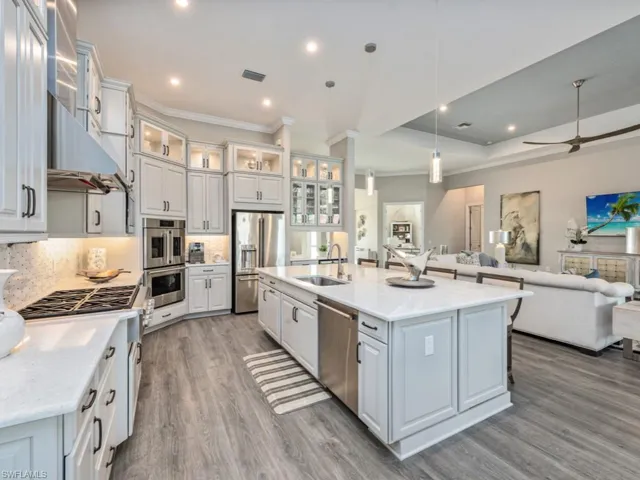 Kitchen with hanging light fixtures, open floor plan, appliances with stainless steel finishes, white cabinetry, and recessed lighting