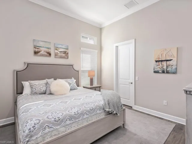 Bedroom with crown molding and wood finished floors