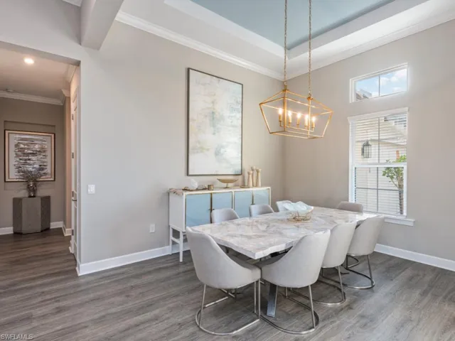Dining space with ornamental molding, wood finished floors, and a chandelier