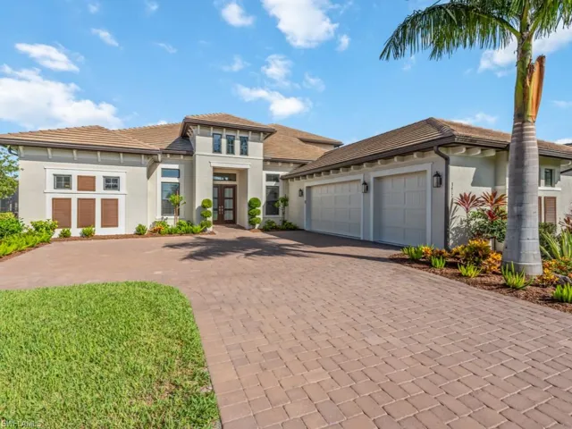 Prairie-style house featuring decorative driveway, stucco siding, a garage, french doors, and a tiled roof
