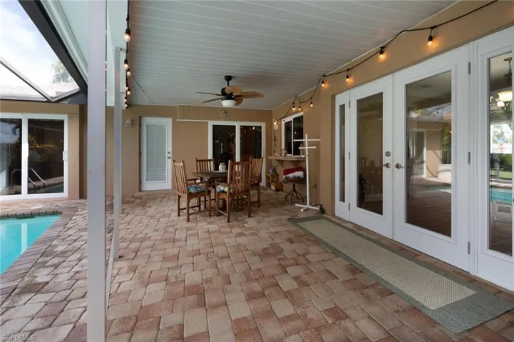 Covered lanai with access to guest bedroom, family room and primary bedroom through sliders, pool bath and dining room access through French doors.