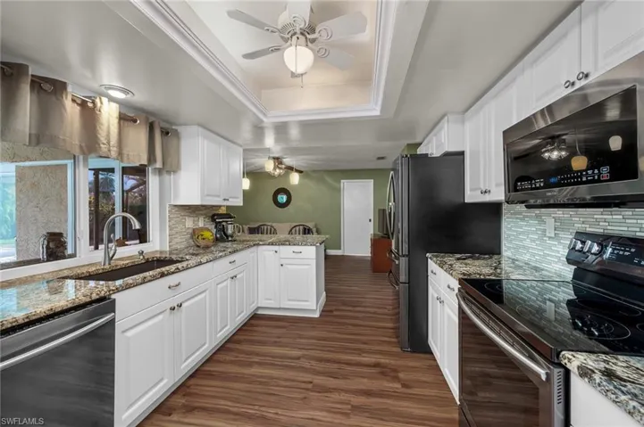 Kitchen adjoins the family room with a breakfast bar and has a pass-through window to the outdoor lanai.
