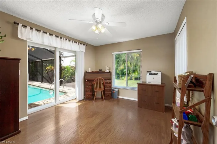 Guest Bedroom with slider to the pool, closet and wood flooring currently used as office.